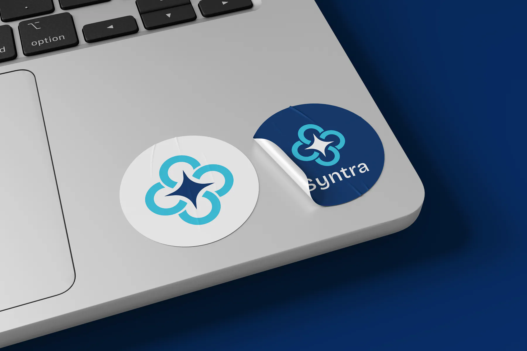 Syntra branded stickers on a laptop